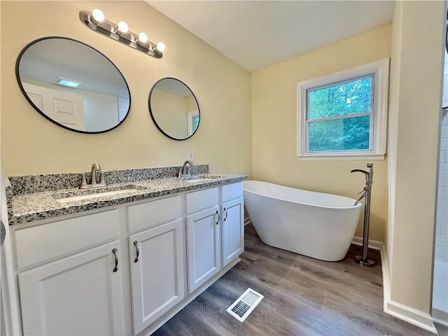 93 Mill Creek Rd, Hiram, GA 30141 - full bath with a soaking tub, visible vents, wood finished floors, and a sink