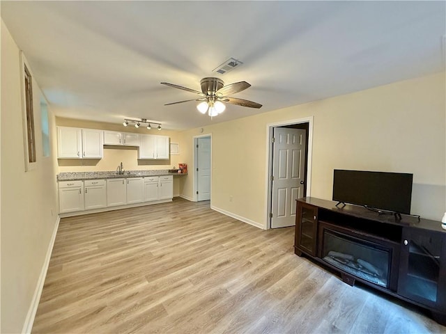 93 Mill Creek Rd, Hiram, GA 30141 - unfurnished living room featuring light wood-style flooring, a sink, visible vents, baseboards, and ceiling fan