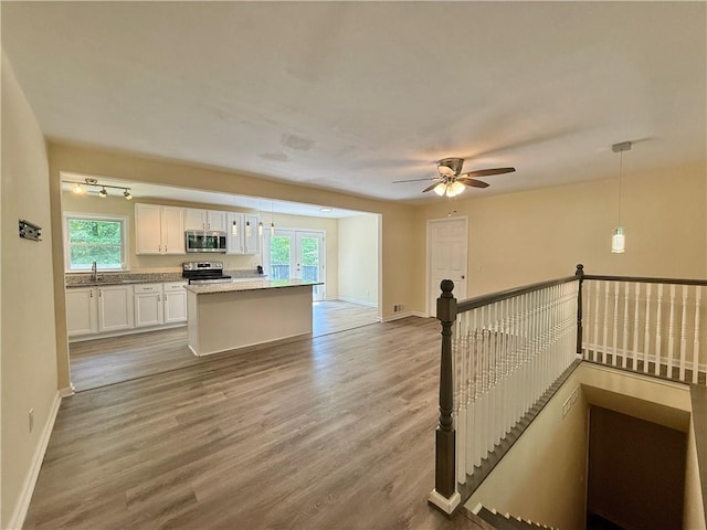 93 Mill Creek Rd, Hiram, GA 30141 - kitchen with wood finished floors, white cabinets, plenty of natural light, and appliances with stainless steel finishes