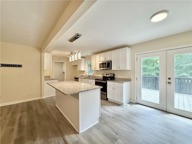 93 Mill Creek Rd, Hiram, GA 30141 - kitchen featuring light wood-style floors, light stone counters, white cabinets, and appliances with stainless steel finishes