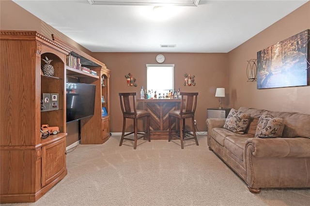 living area featuring a bar, visible vents, and light colored carpet