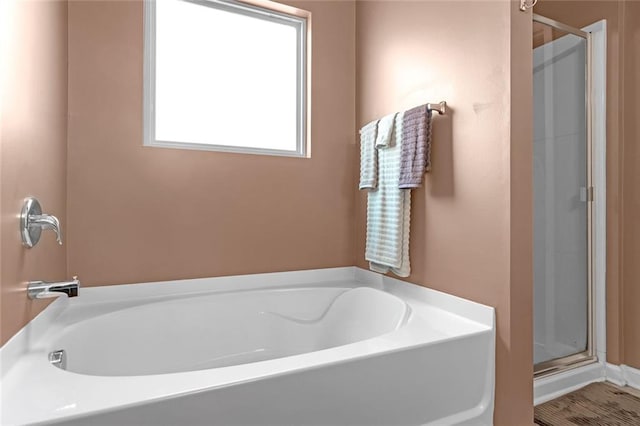 full bath featuring a garden tub and a shower stall