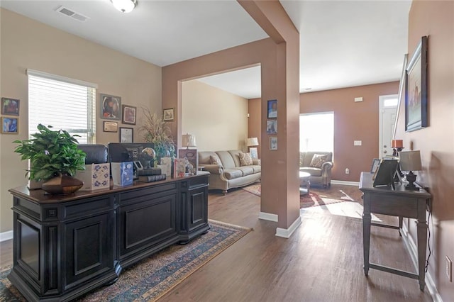 office space with a healthy amount of sunlight, visible vents, baseboards, and wood finished floors