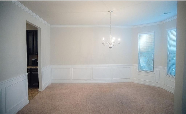 empty room with crown molding, carpet flooring, and a chandelier