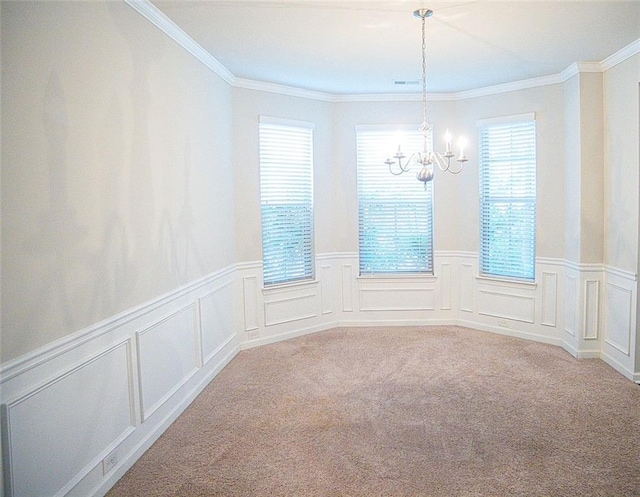 spare room featuring an inviting chandelier, ornamental molding, and light carpet