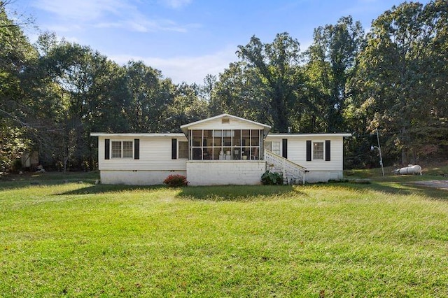 view of front of property featuring a front lawn and a sunroom