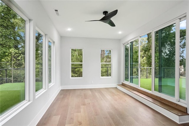 unfurnished sunroom featuring ceiling fan and a healthy amount of sunlight