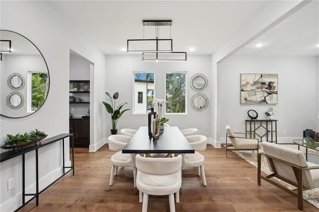 dining area with hardwood / wood-style flooring and a notable chandelier