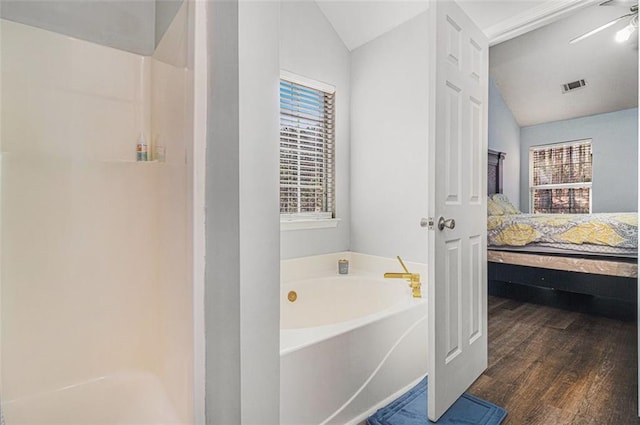 bathroom with hardwood / wood-style flooring, lofted ceiling, and a washtub