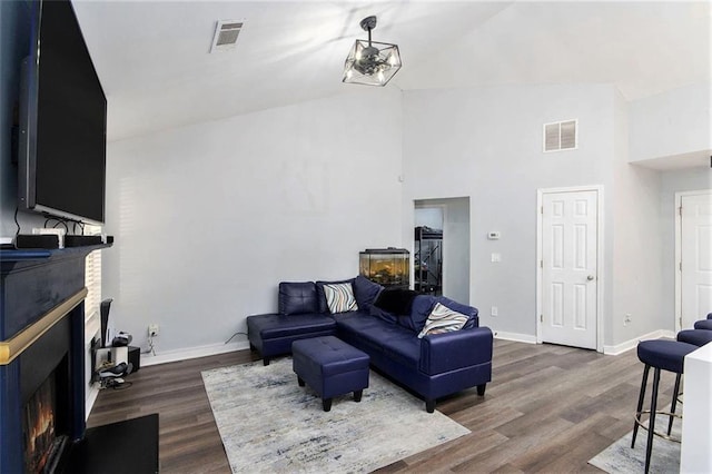 living room with dark wood-type flooring and high vaulted ceiling