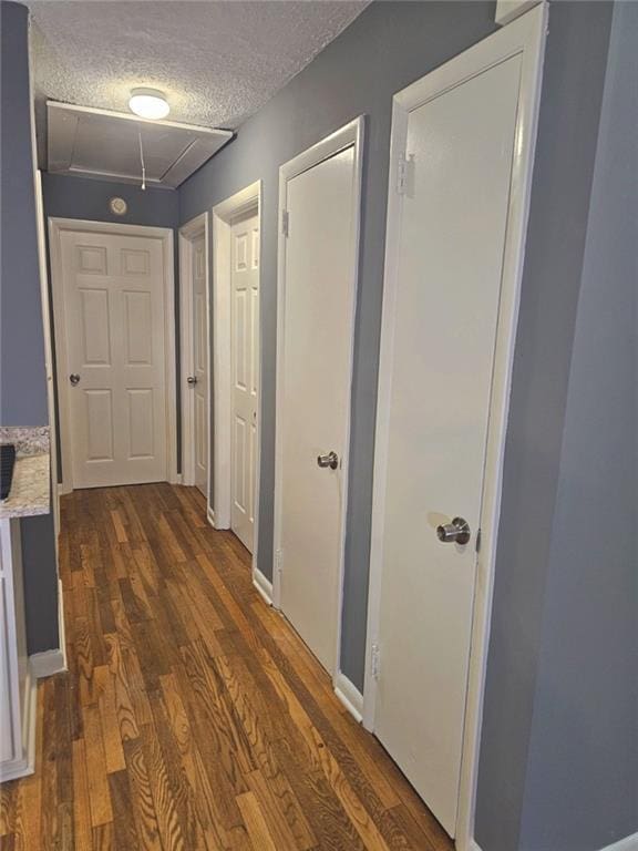 1150 Goldsmith Rd, Stone Mountain, GA 30083 - hallway with attic access, dark wood-style flooring, and a textured ceiling