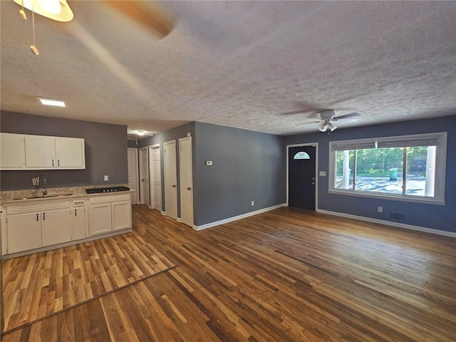 1150 Goldsmith Rd, Stone Mountain, GA 30083 - unfurnished living room with a sink, dark wood-type flooring, ceiling fan, baseboards, and a textured ceiling