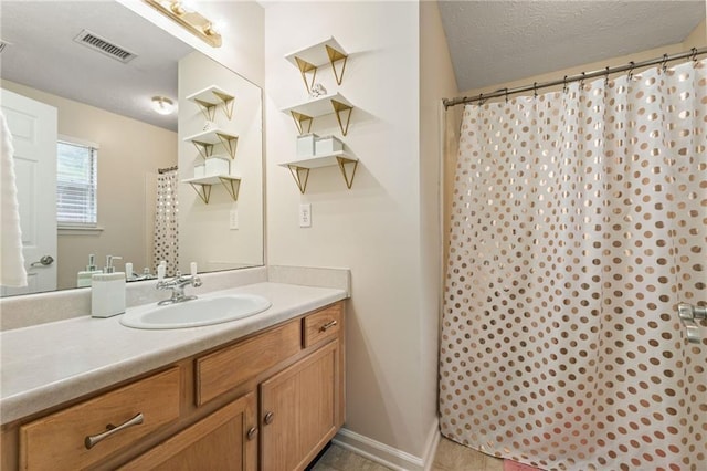 full bathroom featuring baseboards, visible vents, curtained shower, a textured ceiling, and vanity