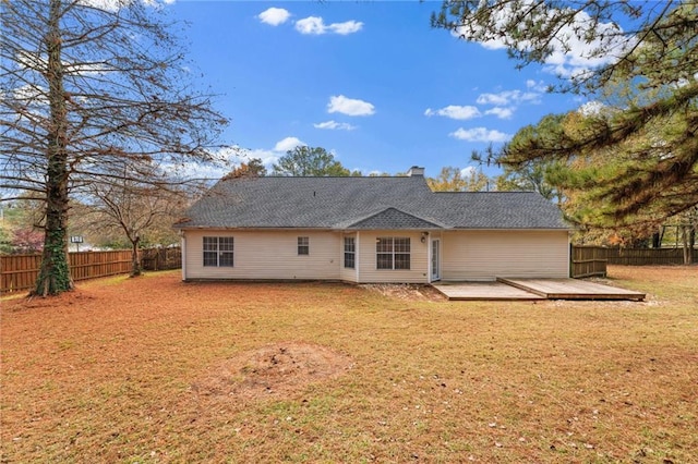 back of house featuring a deck, a shingled roof, a lawn, and fence private yard