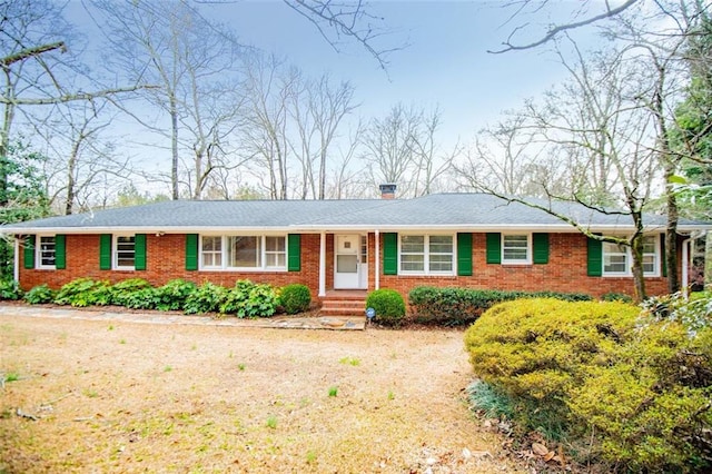 single story home with brick siding and a chimney