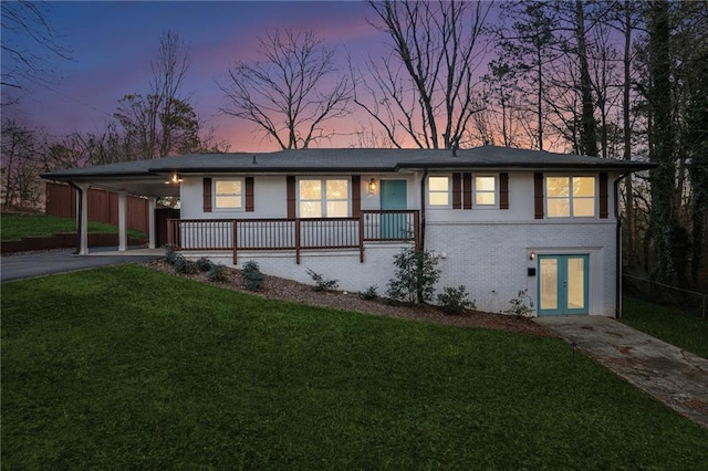 view of front of property with a carport and a lawn