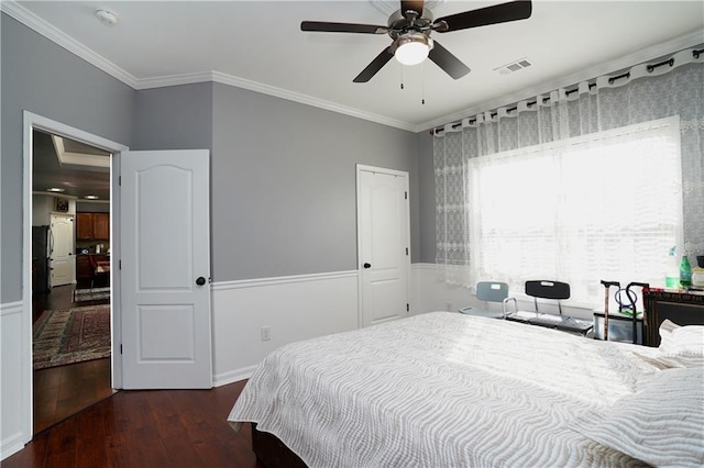 bedroom with ornamental molding, dark wood-type flooring, and ceiling fan