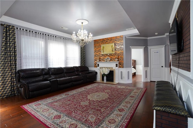 living room with ornamental molding, a chandelier, and dark hardwood / wood-style floors