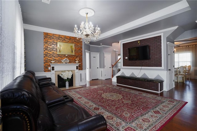 living room featuring ornamental molding, dark hardwood / wood-style flooring, and a chandelier