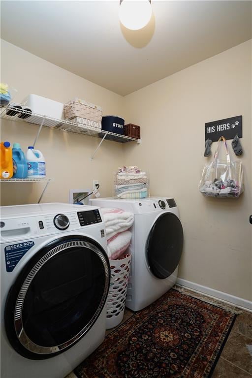 laundry room featuring washer and clothes dryer and dark tile patterned flooring