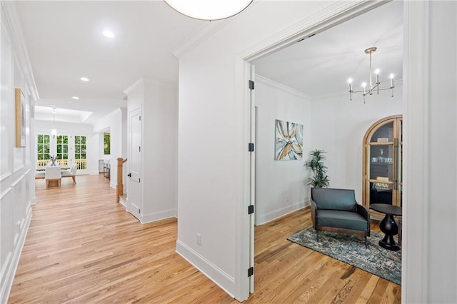 corridor featuring ornamental molding, light wood-style flooring, recessed lighting, a chandelier, and baseboards