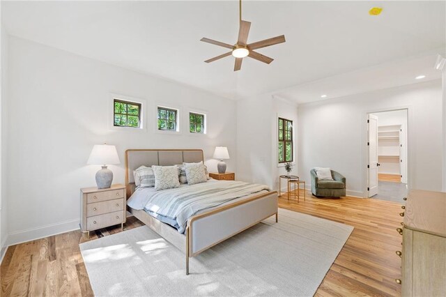 bedroom featuring light wood-type flooring, baseboards, recessed lighting, ceiling fan, and a spacious closet