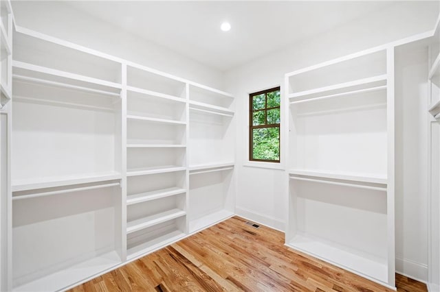 walk in closet with wood finished floors