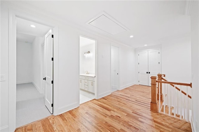 corridor featuring attic access, an upstairs landing, light wood-type flooring, recessed lighting, and baseboards