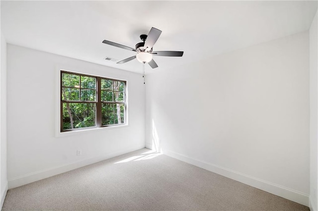 carpeted empty room with baseboards and a ceiling fan