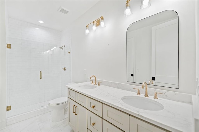 bathroom with a stall shower, toilet, double vanity, and marble finish floors