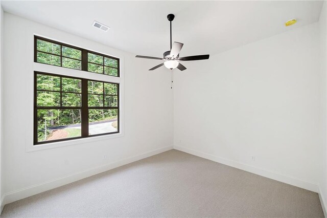 empty room featuring ceiling fan, light carpet, and baseboards