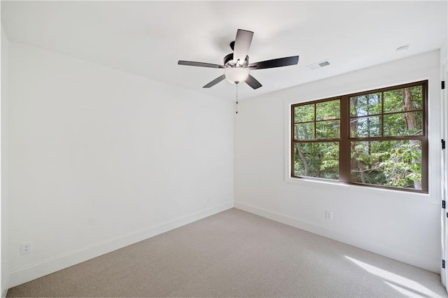 unfurnished room featuring light colored carpet, baseboards, and ceiling fan