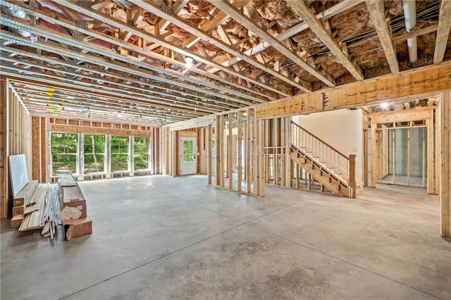 misc room with concrete floors and stairs