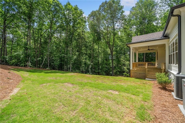 view of grassy yard with ceiling fan and covered porch