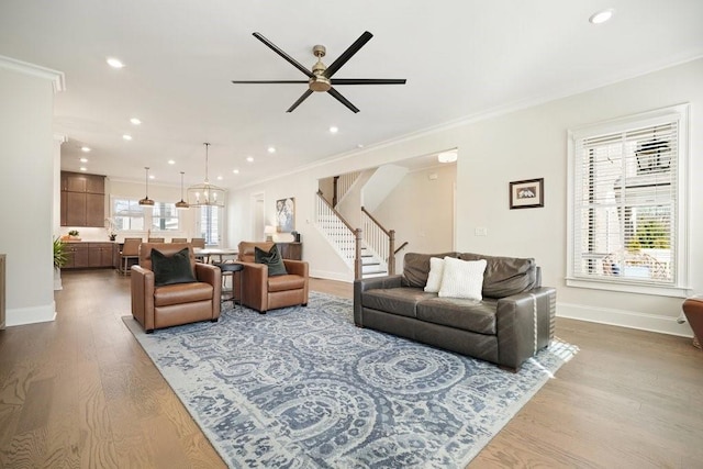 living room with stairs, crown molding, wood finished floors, recessed lighting, and ceiling fan