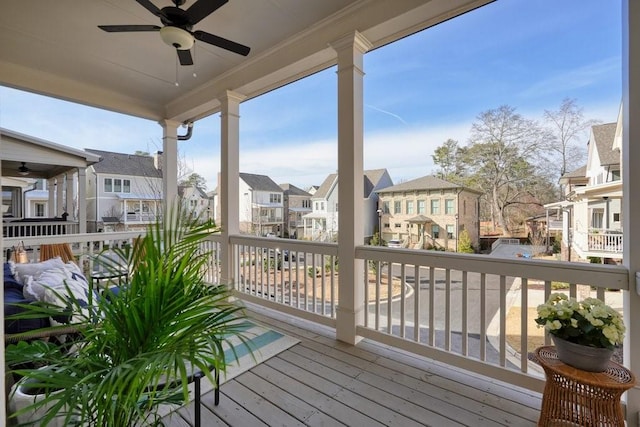 deck with a residential view and a ceiling fan