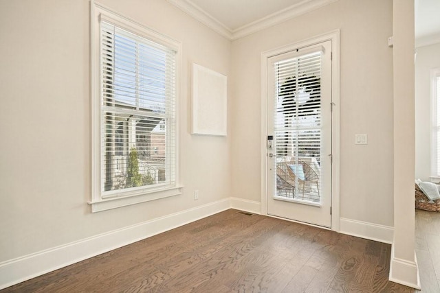 doorway featuring dark wood finished floors, ornamental molding, and baseboards