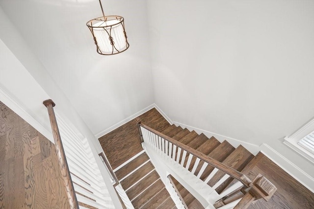 staircase with baseboards and wood finished floors