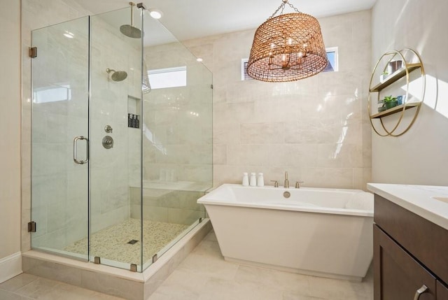 full bathroom with a stall shower, a freestanding tub, and vanity