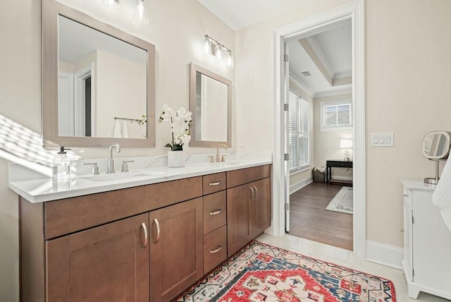 bathroom with double vanity and baseboards