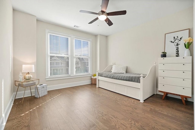 bedroom featuring baseboards, wood finished floors, and ceiling fan