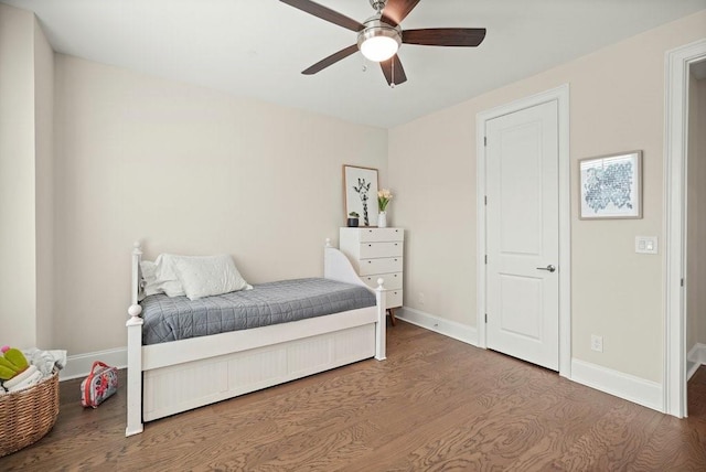 bedroom with wood finished floors, baseboards, and a ceiling fan