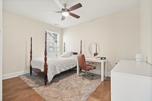 bedroom featuring baseboards, wood finished floors, and a ceiling fan