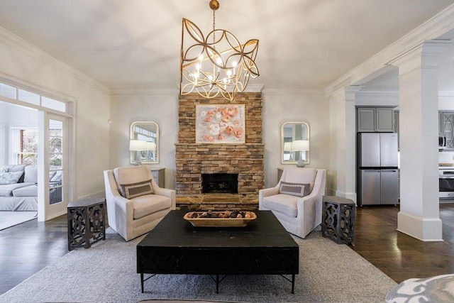 living room with dark wood-style floors, a fireplace, ornate columns, and ornamental molding