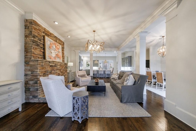 living area featuring ornamental molding, dark wood finished floors, decorative columns, and an inviting chandelier