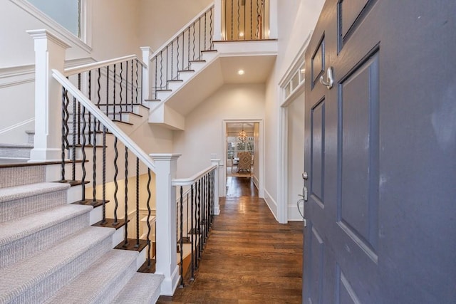 entryway featuring recessed lighting, a towering ceiling, baseboards, and wood finished floors