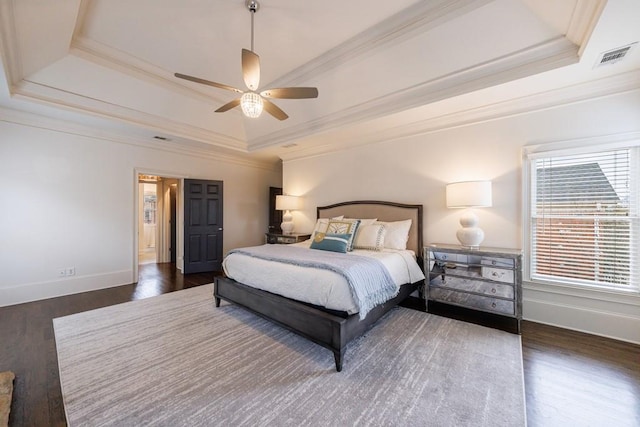 bedroom featuring a raised ceiling, crown molding, and wood finished floors