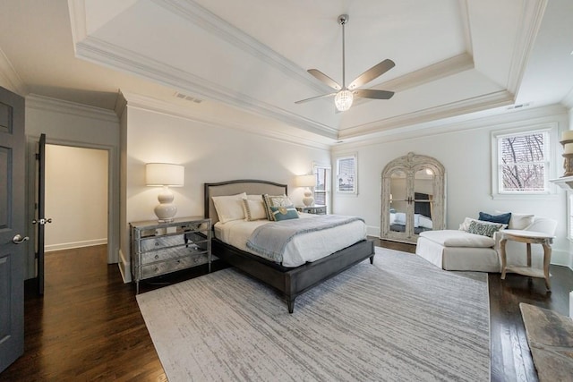 bedroom featuring visible vents, crown molding, a tray ceiling, and dark wood-style flooring