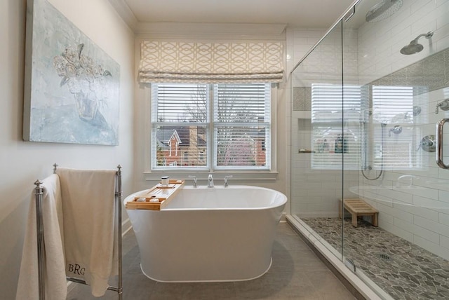 full bath featuring ornamental molding, tile patterned flooring, a freestanding bath, and a shower stall