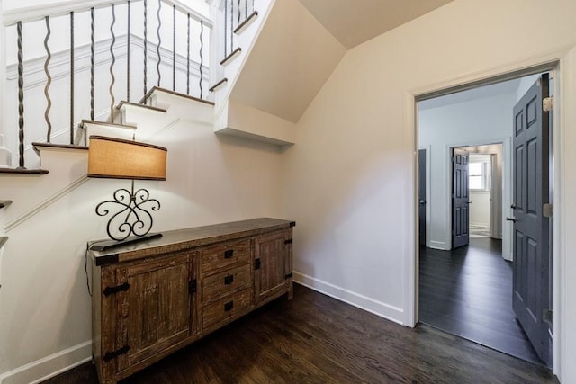 hallway with dark wood-style floors, stairway, and baseboards